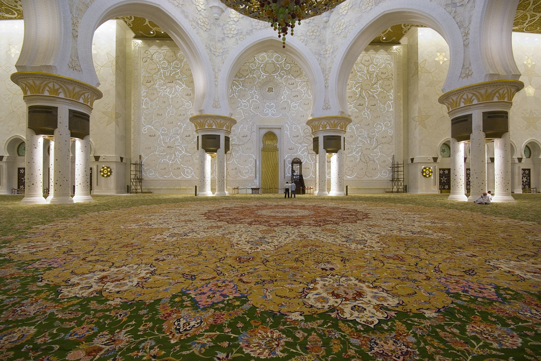 Interior of Sheikh Zayed Mosque in Abu Dhabi, showcasing lighting and carpet.