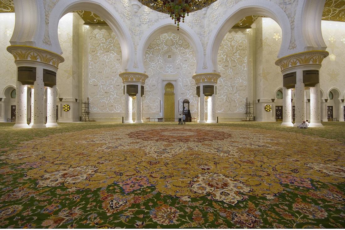 Interior of Sheikh Zayed Mosque in Abu Dhabi, showcasing lighting and carpet.