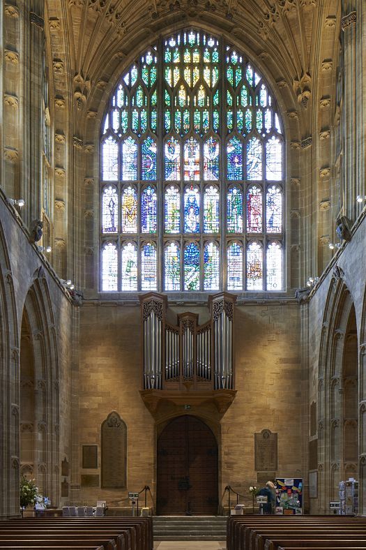Sherborne Abbey interior featuring stained glass and organ, illuminated by ERCO LED lighting.