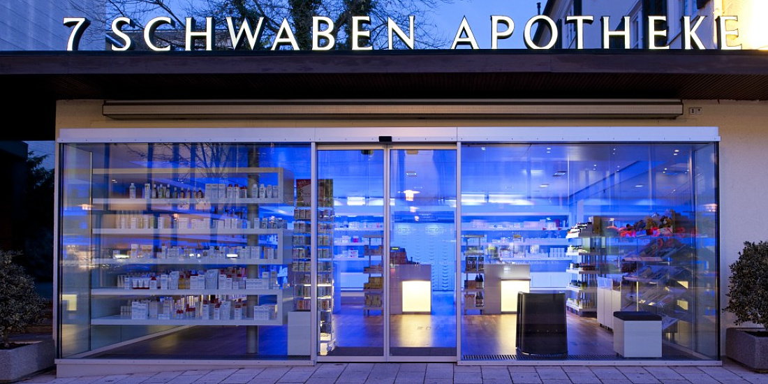 'Sieben Schwaben' Pharmacy featuring ERCO lighting for efficient vertical illumination and color effects.
