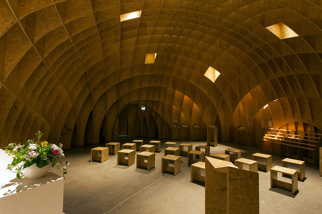 Siegerland Motorway Church interior featuring wooden structure and ERCO lighting for contemplation.