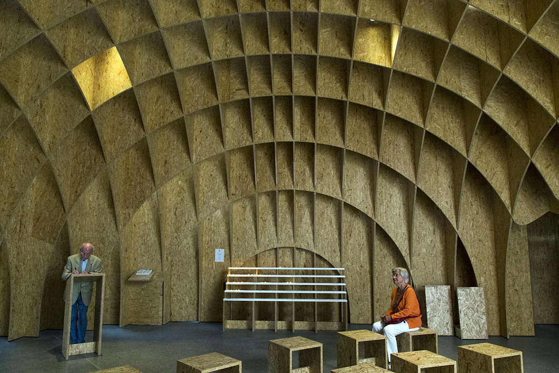 Siegerland Motorway Church interior featuring wooden structure and light accents.