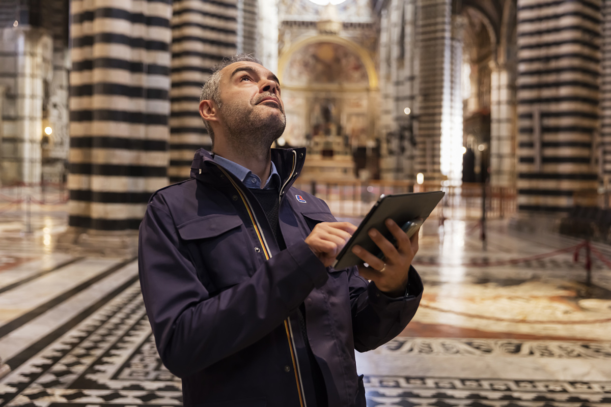 Man with tablet in Siena Cathedral, using ERCO Stella spotlights for wireless LED lighting control.