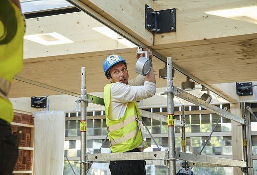 Electrician installing ERCO spotlights in a sustainable building at Solar Decathlon Europe 21/22.