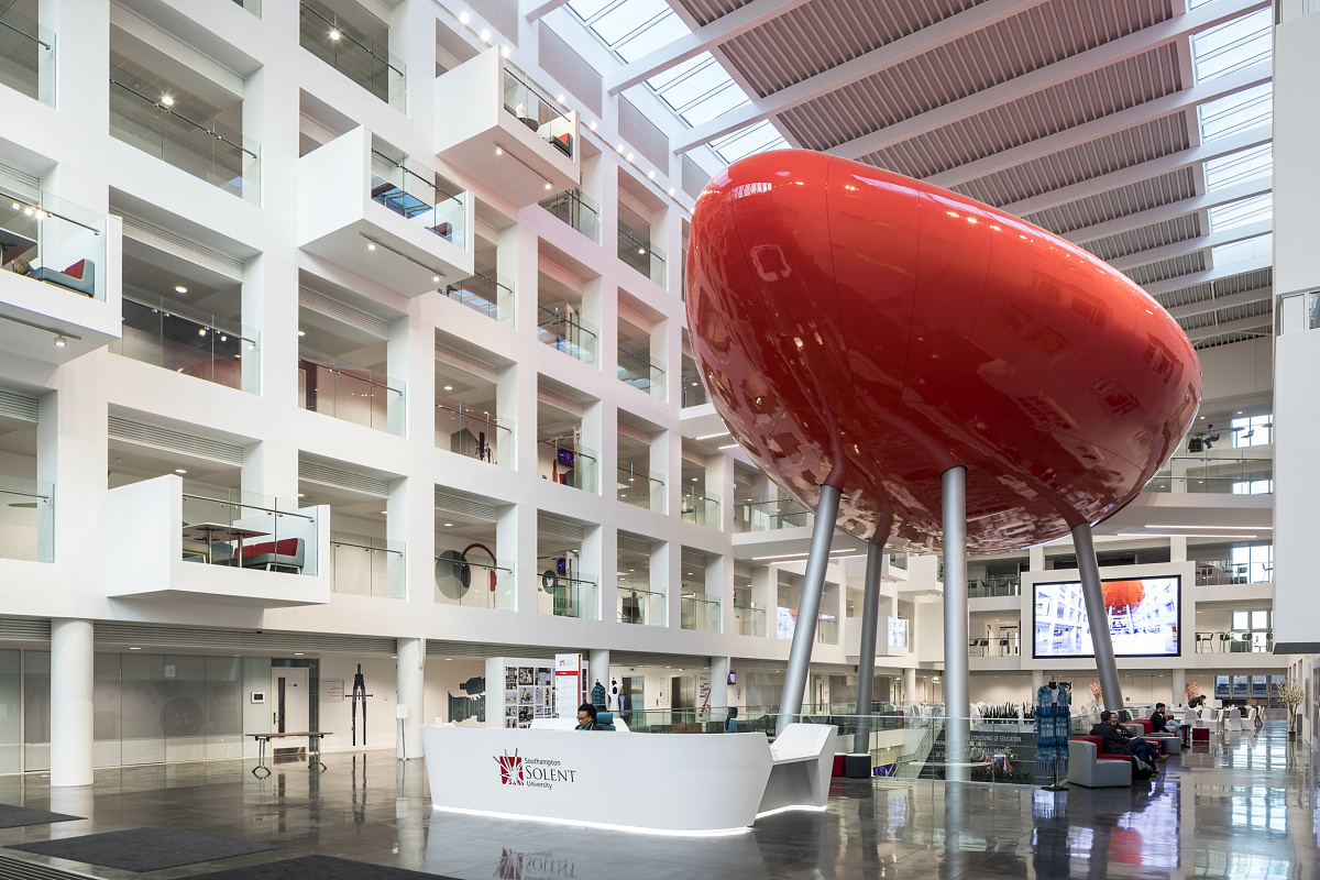 Spark Building, Solent University: Reception area featuring a striking red sculpture and ERCO LED lighting.