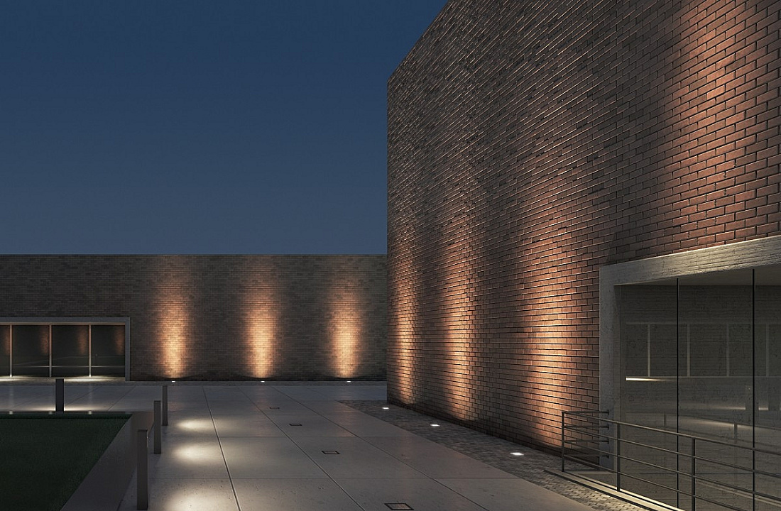 ERCO facade lighting with wallwashers creating uniform light distribution on a brick building.