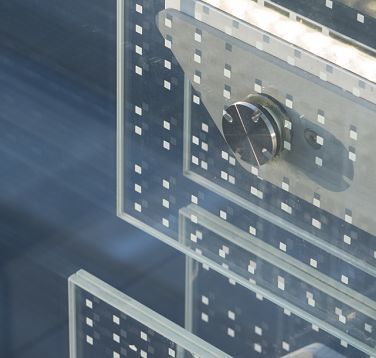 Close-up of SPG Headquarters Genevas glass lamellae facade, illuminated by ERCO LED facade luminaires.