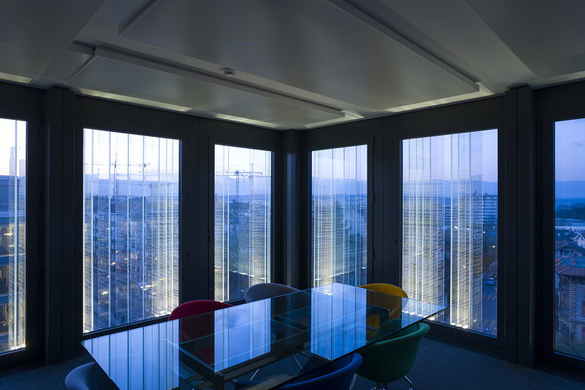 SPG Headquarters Geneva: ERCO LED facade lighting and glass lamellae create a unique 'second skin'.