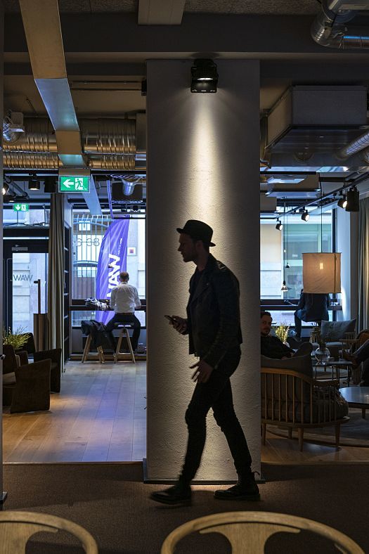 ERCO LED spotlight illuminates a man in a modern office, part of the Work away from Work project.