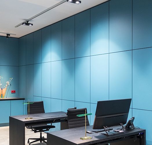 ERCO Pollux spotlights illuminate a modern Frankfurt design team office with turquoise walls.