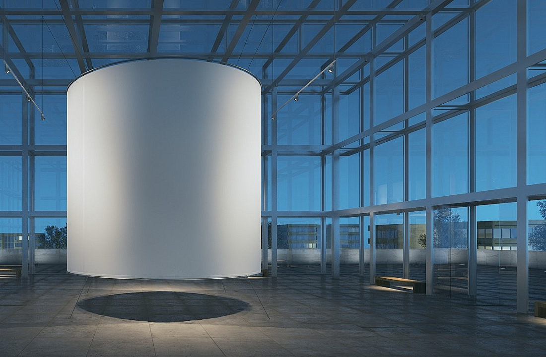 Cylindrical display with uniform lighting in a modern, glass-walled space.