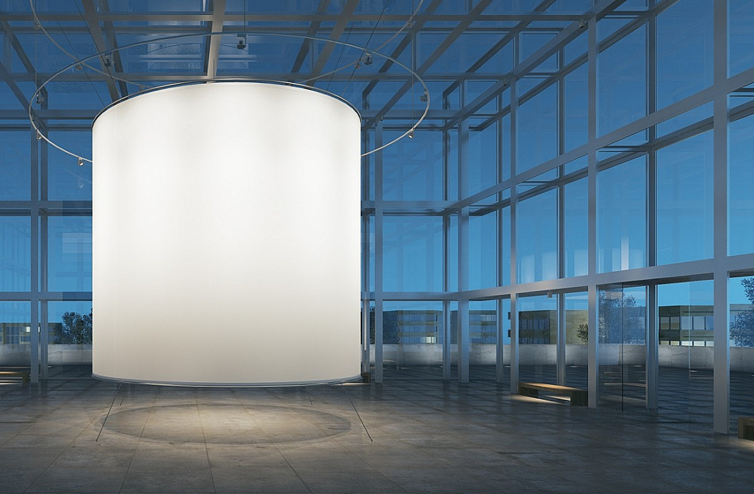 Round illuminated cylinder in a modern space, emphasizing form with light.
