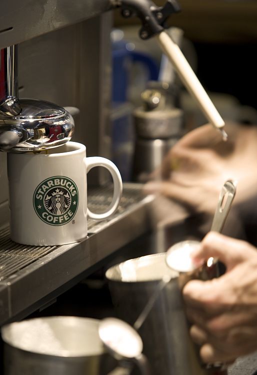 Starbucks mug under LED lighting in a sustainable cafe.