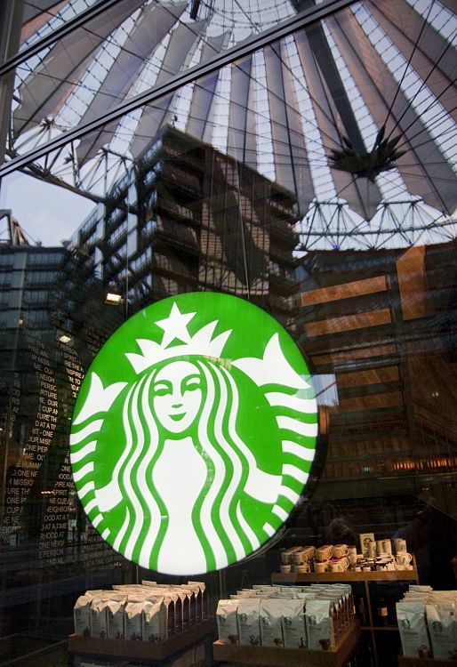 Starbucks Coffee House in Berlin, featuring the iconic logo and architectural reflections.
