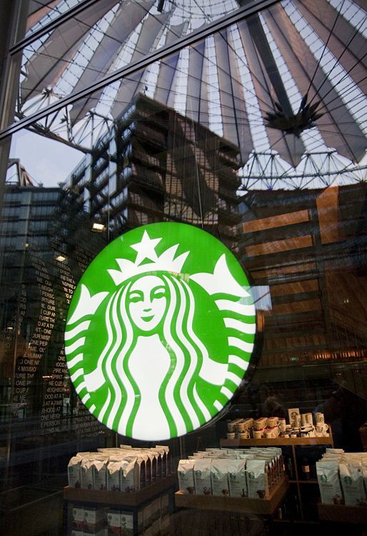 Starbucks Coffee House in Berlin, featuring the iconic logo and architectural reflections.
