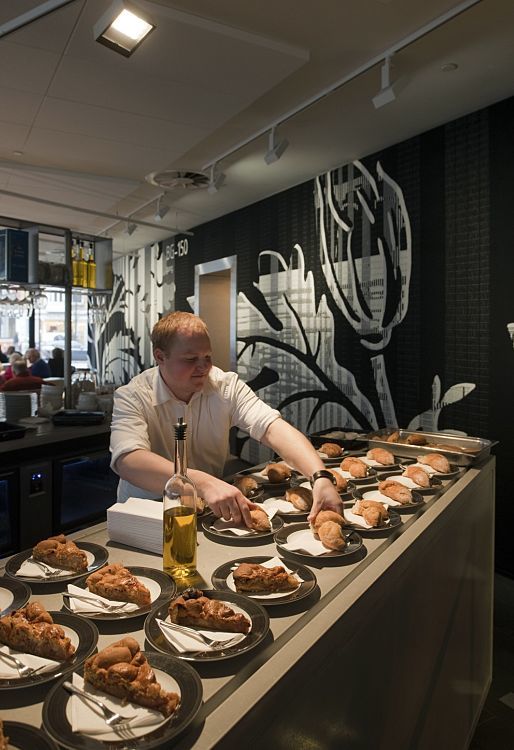 A man prepares food under ERCO lighting at the Stedelijk Museum, Amsterdam.