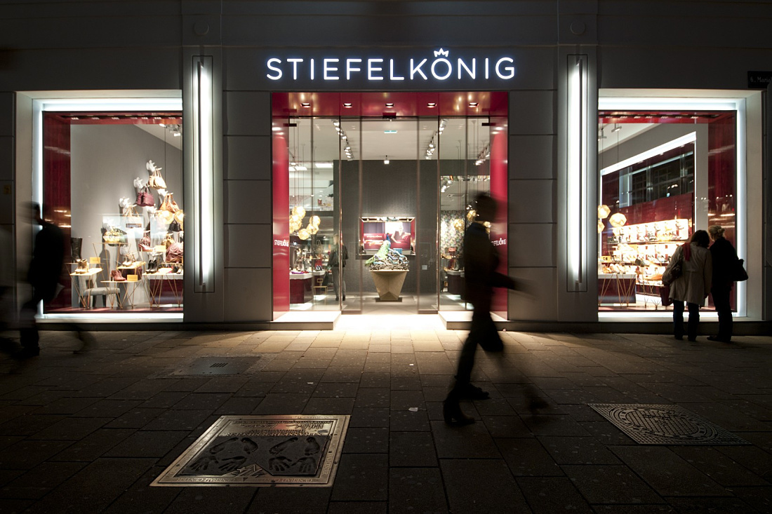 Stiefelkönig shoe shop facade illuminated by ERCO LEDs in Vienna.
