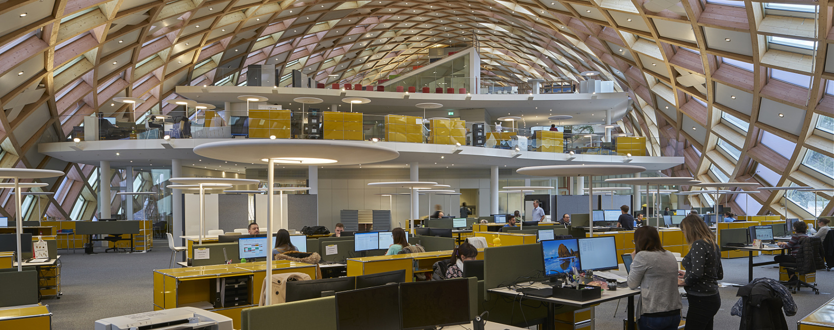 ERCO Gimbal downlights in Swatch HQ, Biel, providing glare-free office lighting beneath a wooden dome.