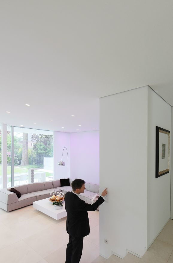 Man using ERCO lighting control in Villa Linari, Hamburg. LED technology creates ambiance.