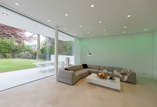 Villa Linari living room featuring ERCO LED lighting and a large window to the garden terrace.