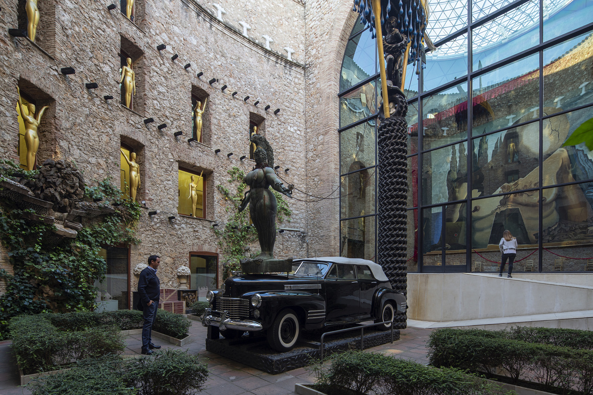Teatre-Museu Dalí courtyard featuring a sculpture atop a Cadillac, illuminated by ERCO spotlights.