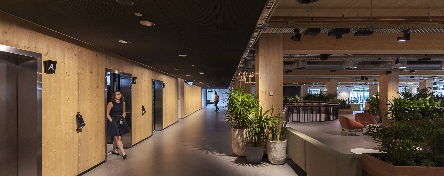 ERCO LED lighting in timber building: Office floor with elevators and lounge area.