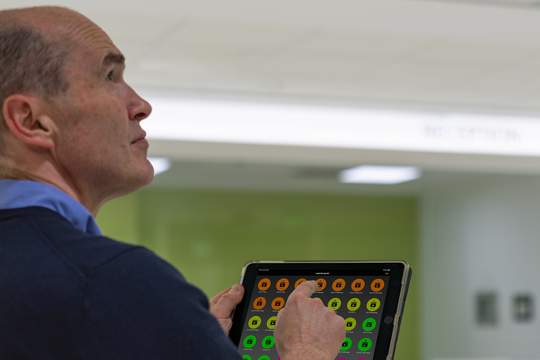Man using a tablet to control ERCO lighting via Bluetooth in Ulster Hospital.