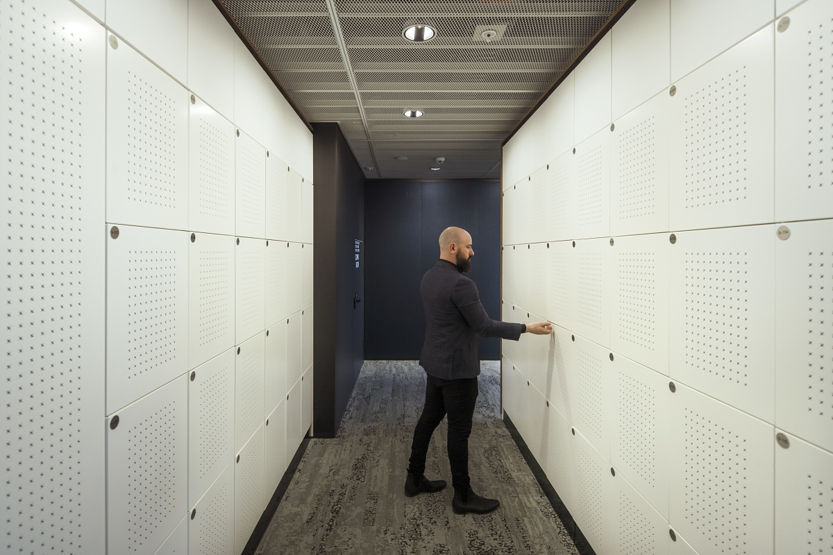 ERCO Jilly downlights illuminate lockers in a modern office for flexible lighting.