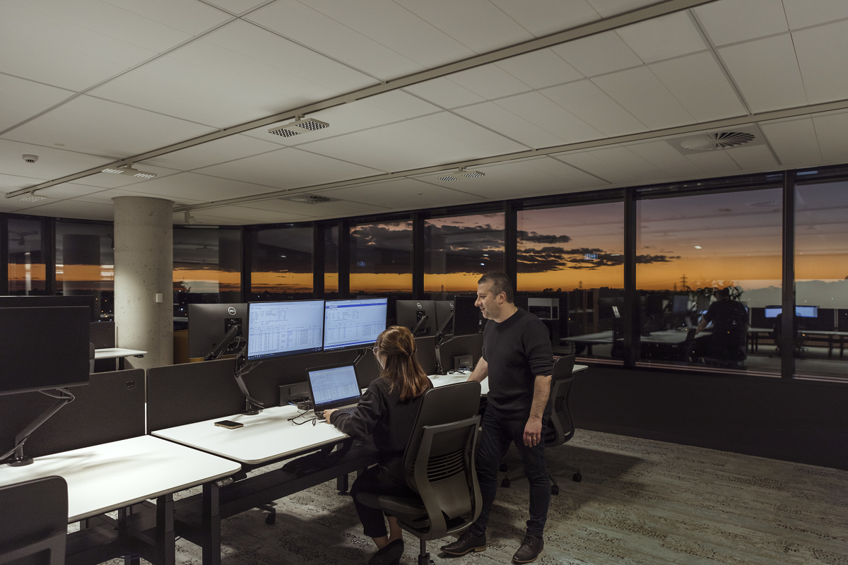 ERCO Jilly downlights illuminate a modern VicRoads office with flexible lighting and two people.