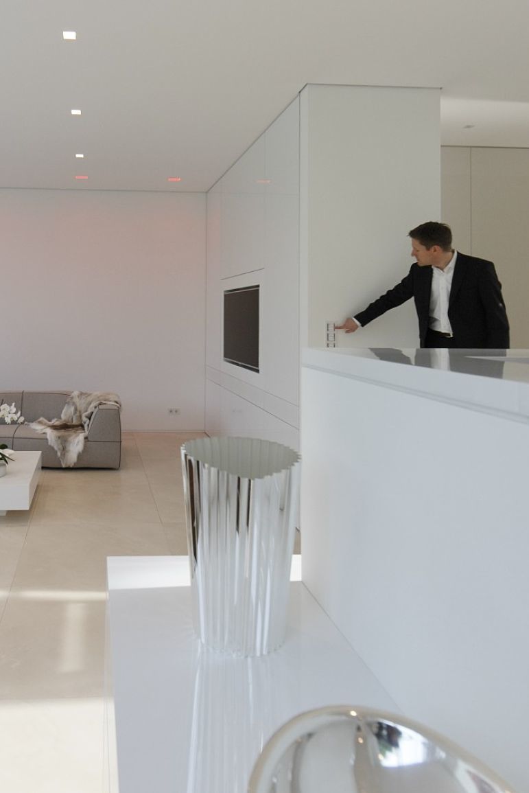 Villa Linari: Man adjusts Quintessence RGBW downlights for ambient lighting.