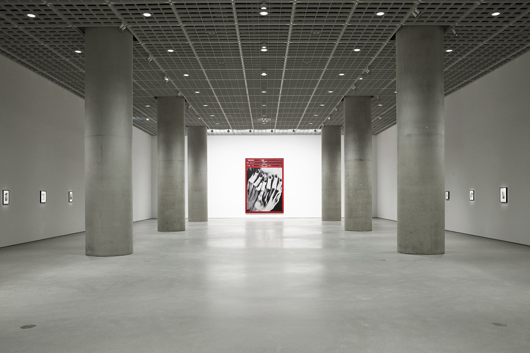 Art gallery featuring concrete pillars and a red artwork, emphasizing visual perception.