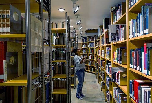 ERCO LED lighting in Vorarlberg State Library enhances vertical illuminance on bookshelves for better book finding.