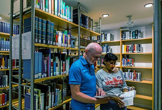 Readers in Vorarlberg State Library with ERCO LED lighting.