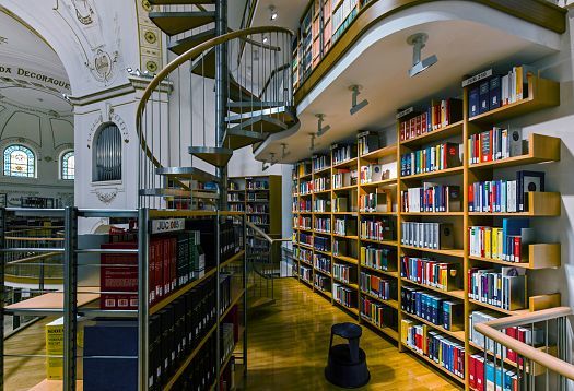 ERCO LED lighting in Vorarlberg State Library, showcasing bookshelves and spiral staircase.