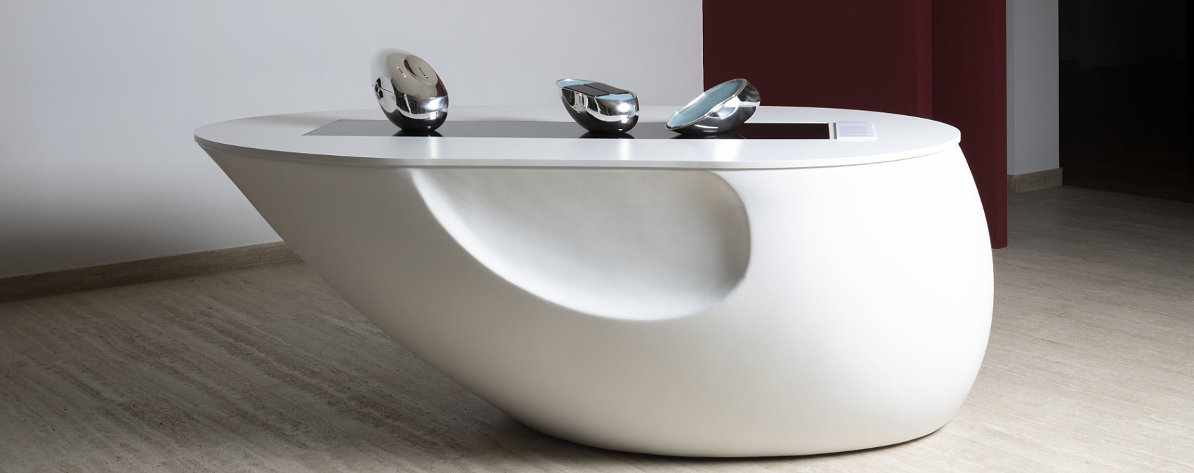 Exhibition pieces on a white table, illuminated by ERCO LED lighting.