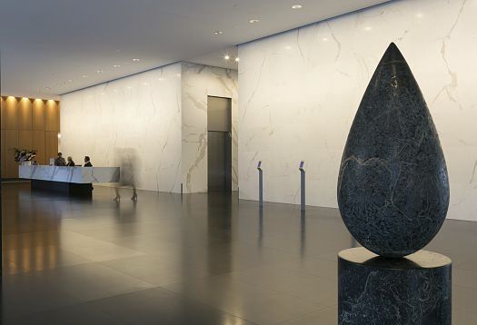 Vertical lighting highlights the marble wall, creating orientation in the space.