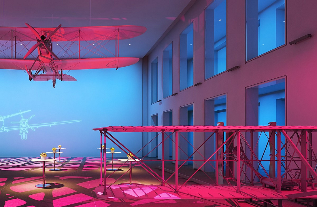 Colored ERCO lighting accentuates a model airplane and bridge structure in an exhibition space.