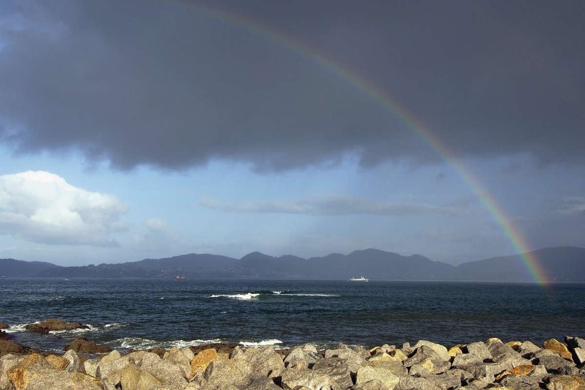 Rainbow over the sea, an example of natural light phenomena and orientation in landscape.