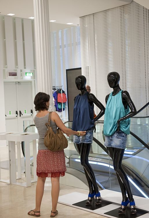 Customer views ZARA fashion on mannequins in Palazzo Bocconi, illuminated by ERCO Optec spotlights.